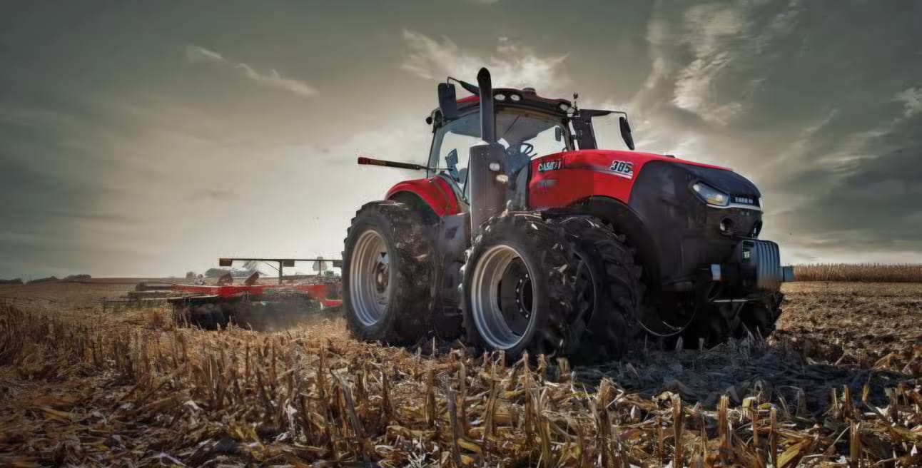 Red tractor in cornfield at dusk
